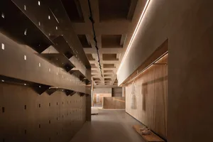Modern retail storefront featuring minimalist design with concrete walls and shelves.