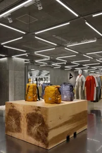 Retail clothing shop featuring modern, minimalist design with wooden and concrete elements.
