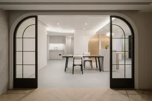 A minimalist modern home office with a concrete floor and white walls.