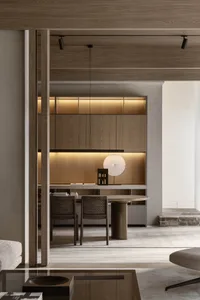 A modern home office with wooden furniture and floor-to-ceiling shelves.