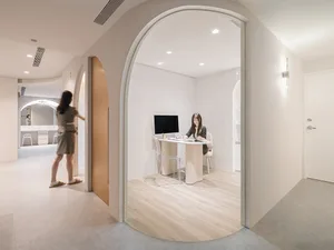 A modern minimalist office space featuring a clean, open design with wooden elements.