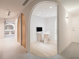 Modern office space with white wooden furnishings and minimalist design.