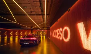 A modern parking garage interior with metallic finishes and neon lighting.