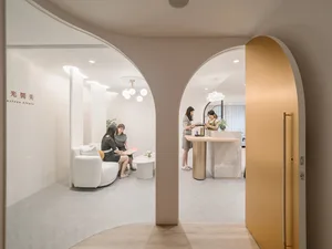 People in a spa clinic with white marble decor, modern furniture, and minimalist design.