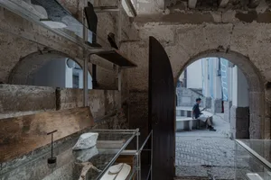 Stone museum interior with industrial design elements and archways.