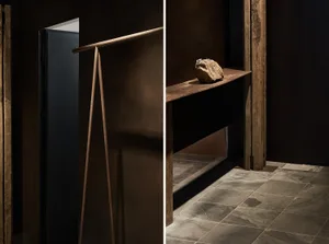 A minimalist interior design featuring wooden and metallic elements with a stone decoration.