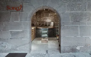 現代簡約的店面外觀，搭配石材建築與玻璃展示櫃。