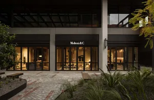 Modern office lobby with glass walls and concrete flooring.
