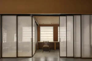 現代辦公空間，設有透明玻璃牆、辦公桌與椅子。