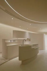 Modern retail storefront with minimalist, white interior design featuring sleek, curved surfaces and a clean, functional layo