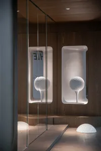 Minimalist golf ball displays mounted on a wooden wall with built-in lighting.