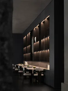 Modern restaurant interior with dark walls, illuminated shelves, and minimalist dining tables and chairs.