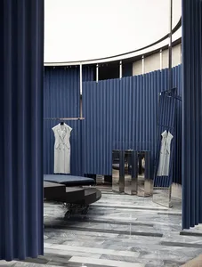 Modern retail storefront featuring blue curtains, marble floors, wood-paneled walls, transparent mirrors, and a white ceiling