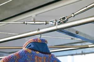 A metal truss structure, showing the crossbars and joints held together with screws and nuts.