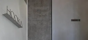 Minimalist, modern door sign made of metal showing the word 'HOKA'.