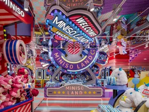 A vibrant, colorful retail shop interior with various toys and stuffed animals arranged on shelves and tables.