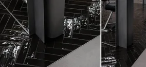 A modern floor with black tiles in a herringbone pattern.