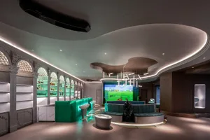 Modern golf simulator room with glass countertops, concrete ceiling, and leather seating