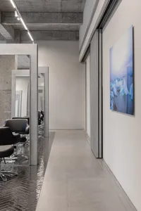 現代美髮沙龍內設有混凝土長椅，採用俐落極簡設計元素，並搭配明亮照明。