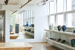 Modern storefront interior displaying products on shelves with wood and granite surfaces.