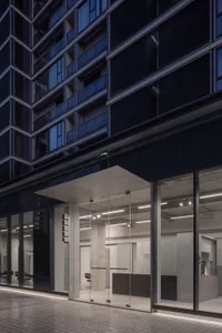 Modern office building with metal-clad exterior and large glass windows.