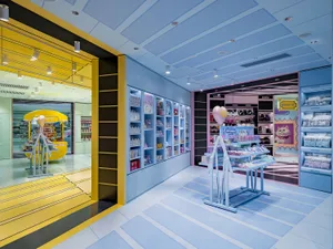 A modern retail storefront featuring yellow and blue colors and a variety of products on display.