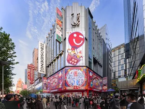 A bustling urban retail storefront adorned with vibrant signage and advertisements, featuring a prominent building with a lar