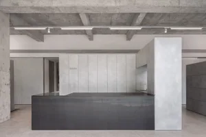 Industrial-style office reception area featuring concrete walls and a metal counter.