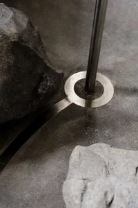 A modern interior with a metal base holding a vertical rod.