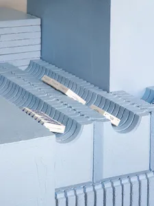 Concrete blocks and rectangular blocks stacked on a blue surface.