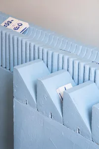 A minimalist concrete shelf with blue and white objects.