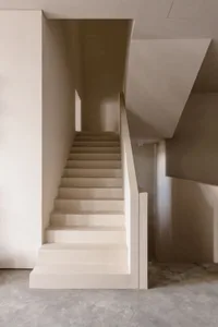 Modern minimalist staircase with concrete steps and walls, featuring clean lines and a simple design.