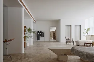 Modern living room with concrete walls and floor, minimalist furniture, and natural light.
