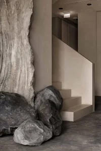 Modern interior space featuring minimalist design with concrete elements and natural lighting.