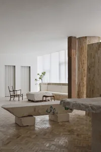A modern living room featuring concrete, stone, and timber materials.