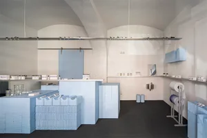 A retail storefront with blue-painted walls and concrete flooring.