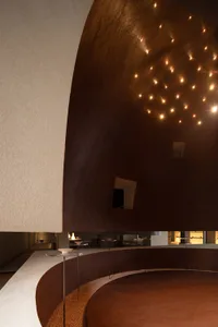 An interior space with a minimalist design featuring clay and metal materials.