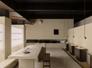 Minimalist restaurant interior with concrete countertops and wooden stools