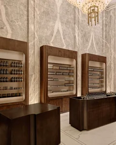 Retail store featuring modern interior design with marble walls and wooden shelves.