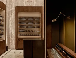 Modern retail store featuring marble walls, wooden shelves, and glass containers.