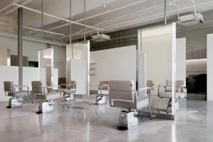 Modern salon interior designed with concrete elements and sleek, minimalist seating.