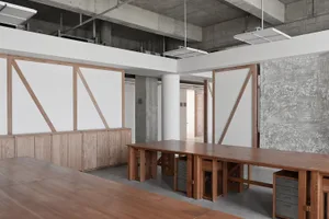 An office space with industrial design featuring wooden furniture and concrete walls.