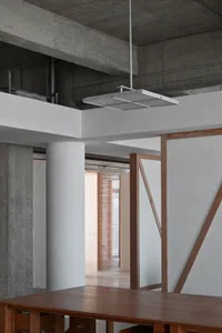 Industrial-style office space featuring concrete and wooden elements with exposed beams and a minimalist design.