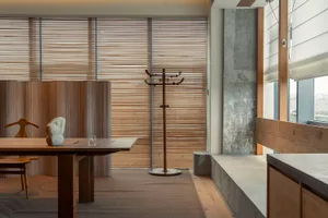 Modern minimalist living room featuring wood furniture and concrete accents.