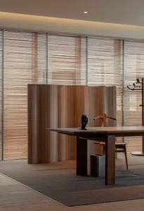 A modern dining room featuring a wooden table with a minimalist design and a wooden chair in front of a large window with woo