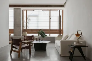 Modern living room interior with concrete floor, wooden furniture, and minimalist design