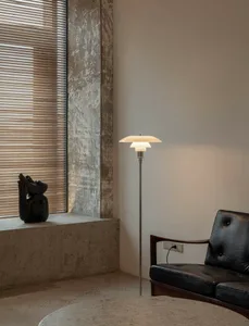 Minimalist living room featuring concrete walls, a concrete floor, and a minimalist floor lamp.