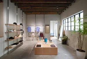 Modern retail store with clothing items displayed on wooden and concrete surfaces