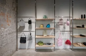 Retail storefront showcasing accessories displayed on metal shelves with light wood shelves.