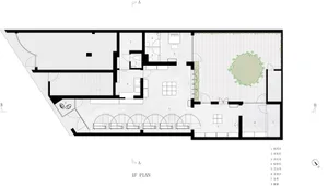 Modern office space with concrete walls and flooring, featuring a central courtyard with greenery.
